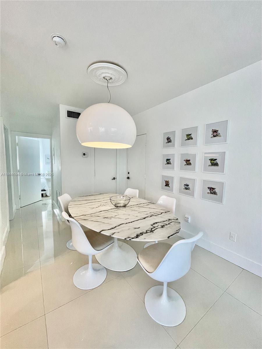 1604 Drexel Avenue, Unit 209 Miami Beach, FL 33139 - Photo 2 of 9 a dining room with granite countertop furniture and a chandelier