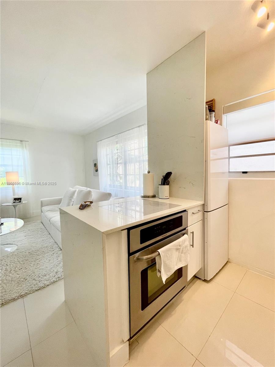 1604 Drexel Avenue, Unit 209 Miami Beach, FL 33139 - Photo 3 of 9 a kitchen with granite countertop a sink and a stove top oven