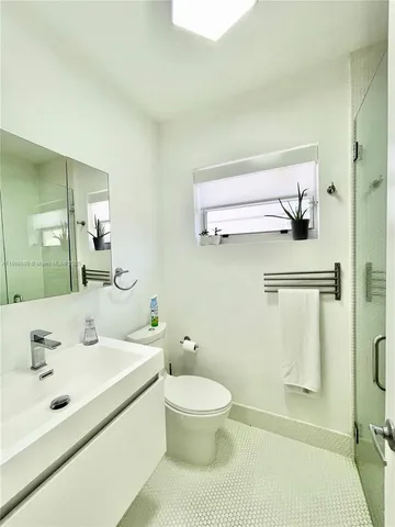 a bathroom with a sink a toilet and a mirror