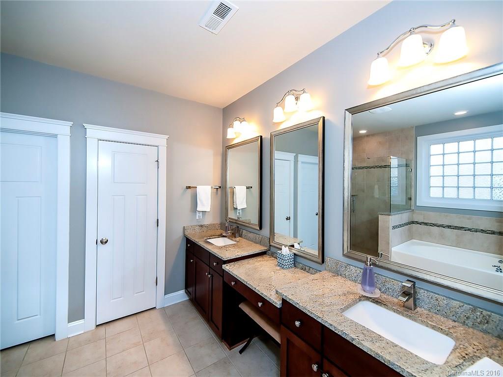 664 Revival Row, Unit 1077 Fort Mill, SC 29708 - Photo 14 of 24 a bathroom with a sink double vanity granite tub shower and a mirror