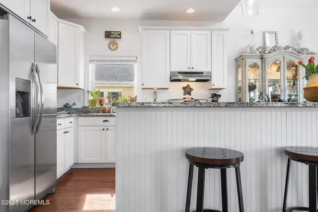 a kitchen with stainless steel appliances granite countertop a sink a stove and refrigerator