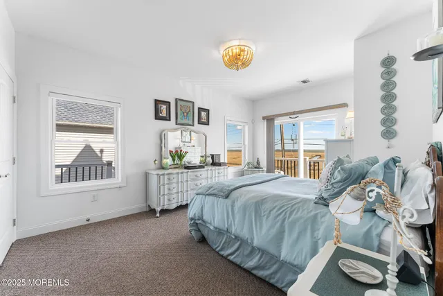 a bedroom with a bed a dresser and next to a window