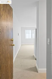 a view of a hallway with wooden floor and a bathroom