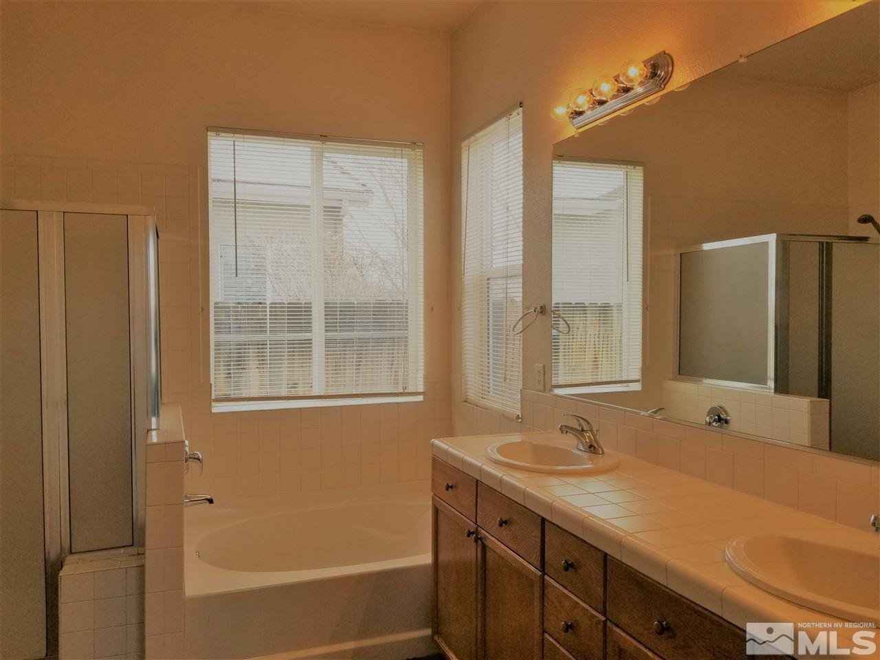 9625 Glen Ridge Drive Reno, NV 89521 - Photo 15 of 23 a bathroom with a tub sink and mirror