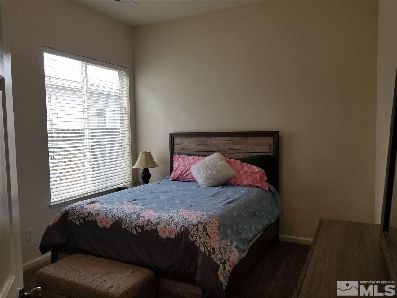 9625 Glen Ridge Drive Reno, NV 89521 - Photo 18 of 23 a bedroom with a bed and a couch next to a window