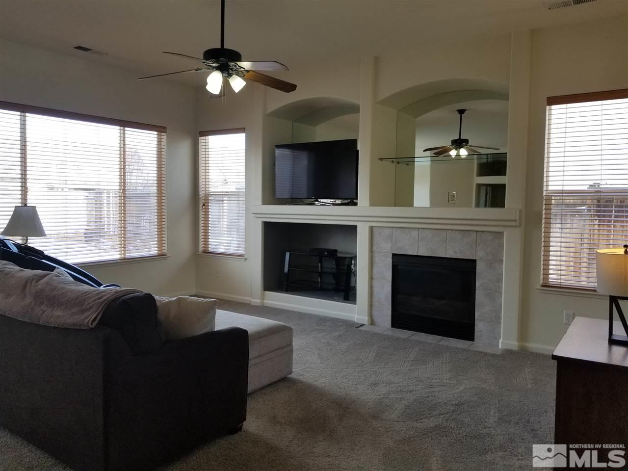 9625 Glen Ridge Drive Reno, NV 89521 - Photo 5 of 23 a living room with furniture a fireplace and a flat screen tv