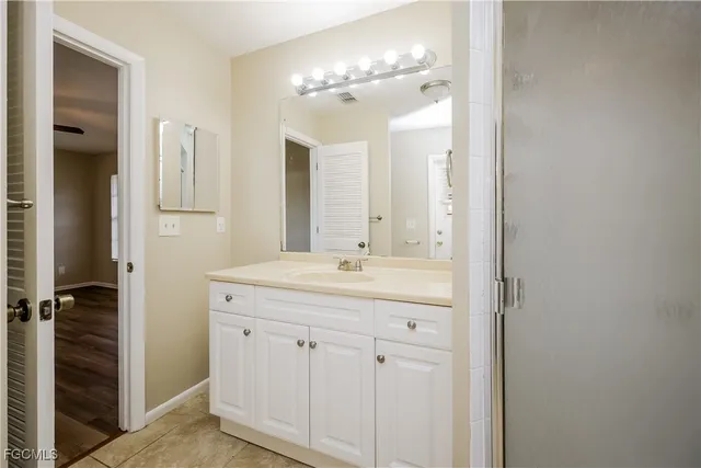 a bathroom with a granite countertop sink a mirror and a shower