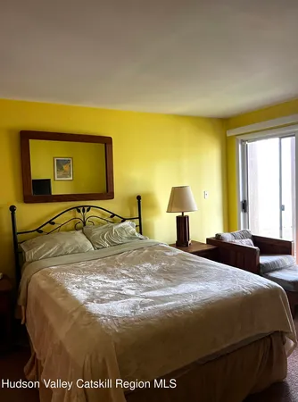 a bed sitting in a bedroom next to a window