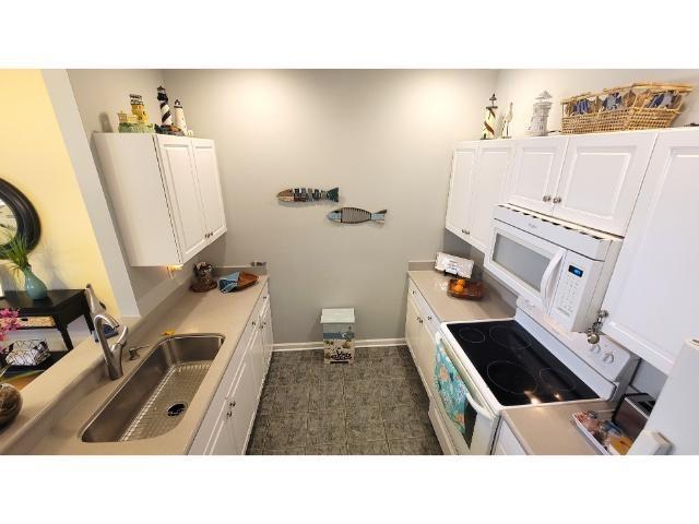 427 Colonial Trace Drive, Unit 1E Longs, SC 29568 - Photo 18 of 35 Kitchen featuring white cabinets, white appliances