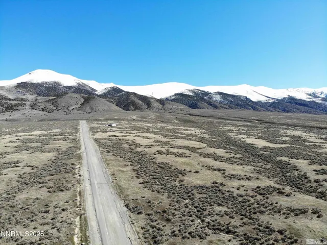 a view of a dry yard with mountains in the background