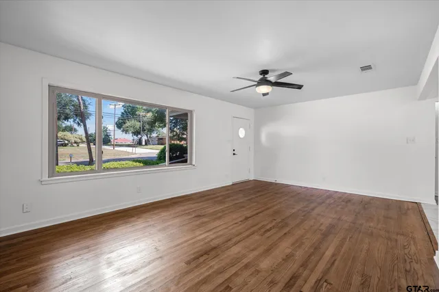 wooden floor in an empty room with a window