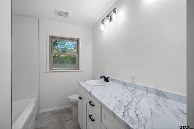 a bathroom with a granite countertop sink and a vanity