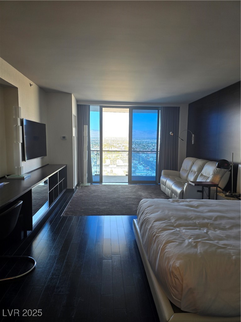 4381 West Flamingo Road, Unit 3109 Las Vegas, NV 89103 - Photo 6 of 28 Bedroom featuring dark wood-style floors and expansive windows