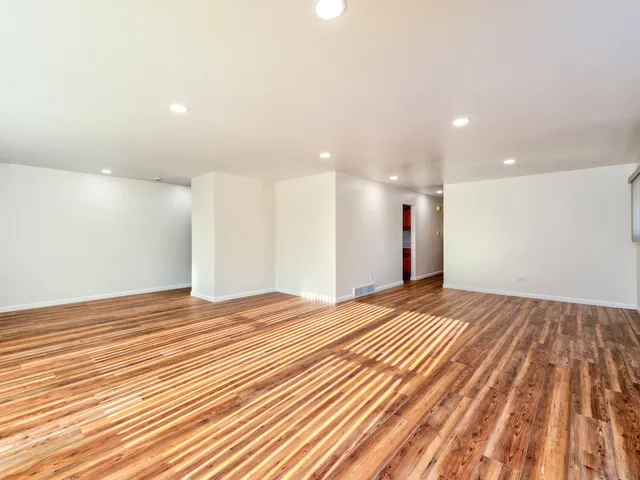 a view of empty room with wooden floor