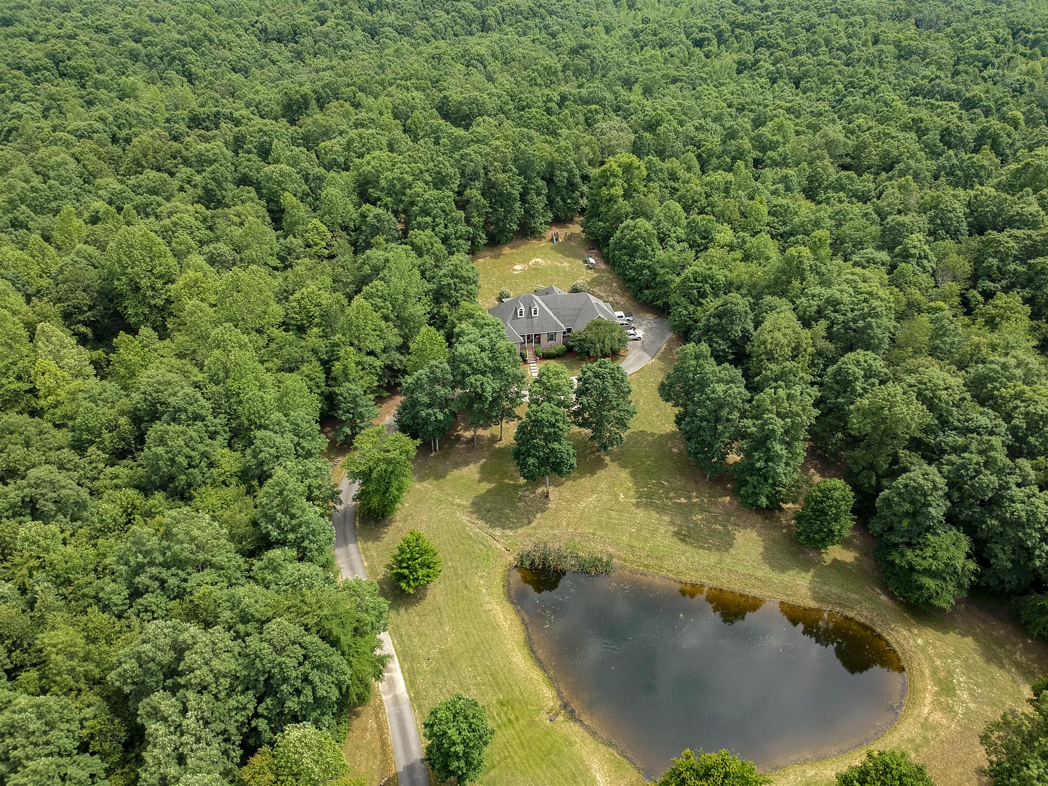 This unique property offers nature's beauty at your fingertips. Hike or ride 4-wheelers through the woods, catch a fish in the stocked pond, relax on the porch and listen to the bullfrogs at night. 
