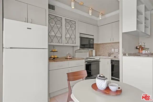 a kitchen with a refrigerator a stove a sink and a dining table