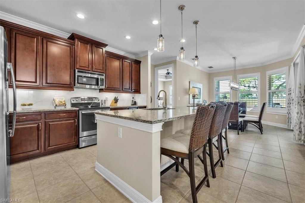 16424 Windsor Way Alva, FL 33920 - Photo 11 of 48 a kitchen with stainless steel appliances granite countertop a stove a sink dishwasher a dining table and chairs with wooden floor