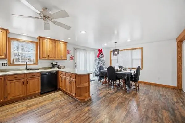a kitchen with stainless steel appliances granite countertop dining table chairs sink and window