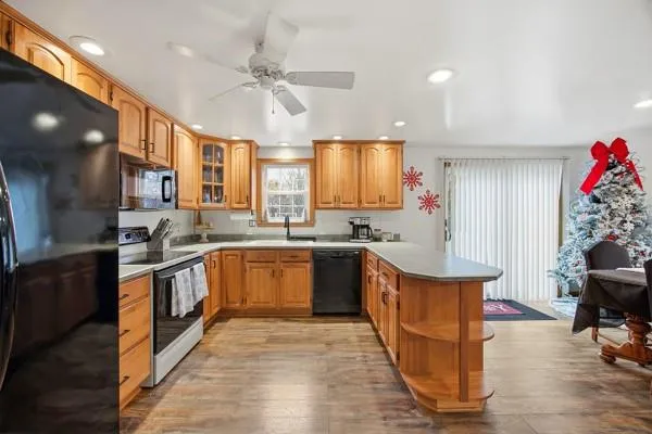 a kitchen with stainless steel appliances granite countertop a sink dishwasher stove top oven and cabinets with wooden floor