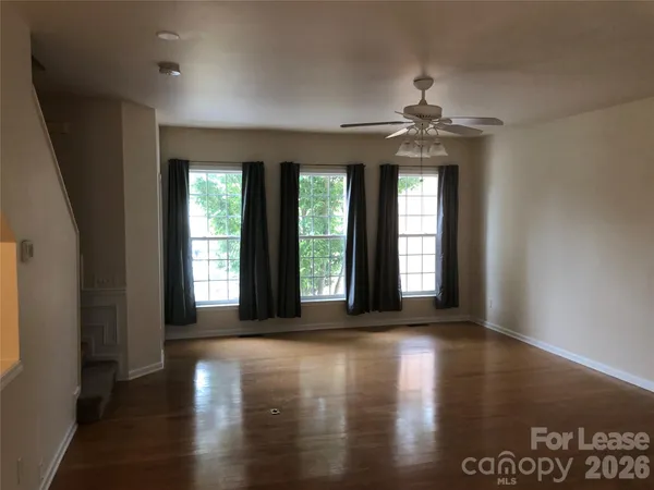a view of a livingroom with wooden floor and a window
