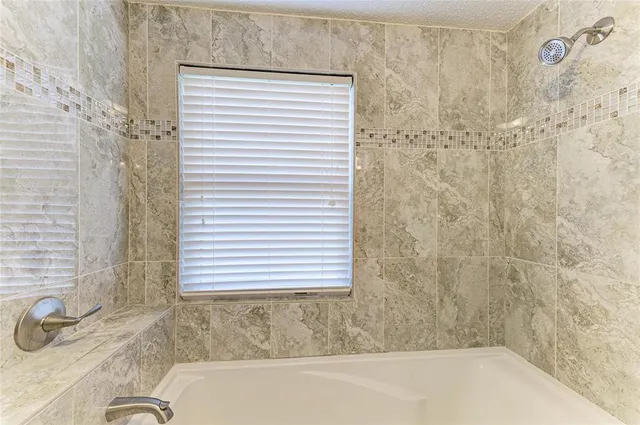 a bathroom with a granite countertop sink and a bathtub