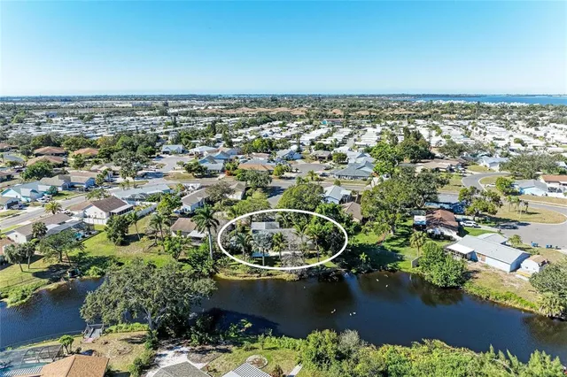 an aerial view of a house with a yard and lake view
