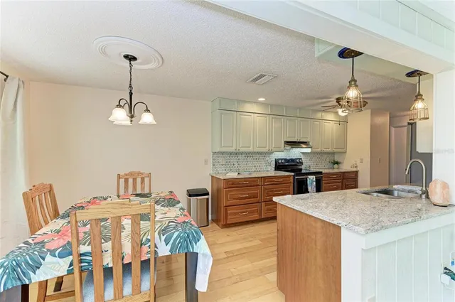 a kitchen with stainless steel appliances wooden floor dining table and chairs