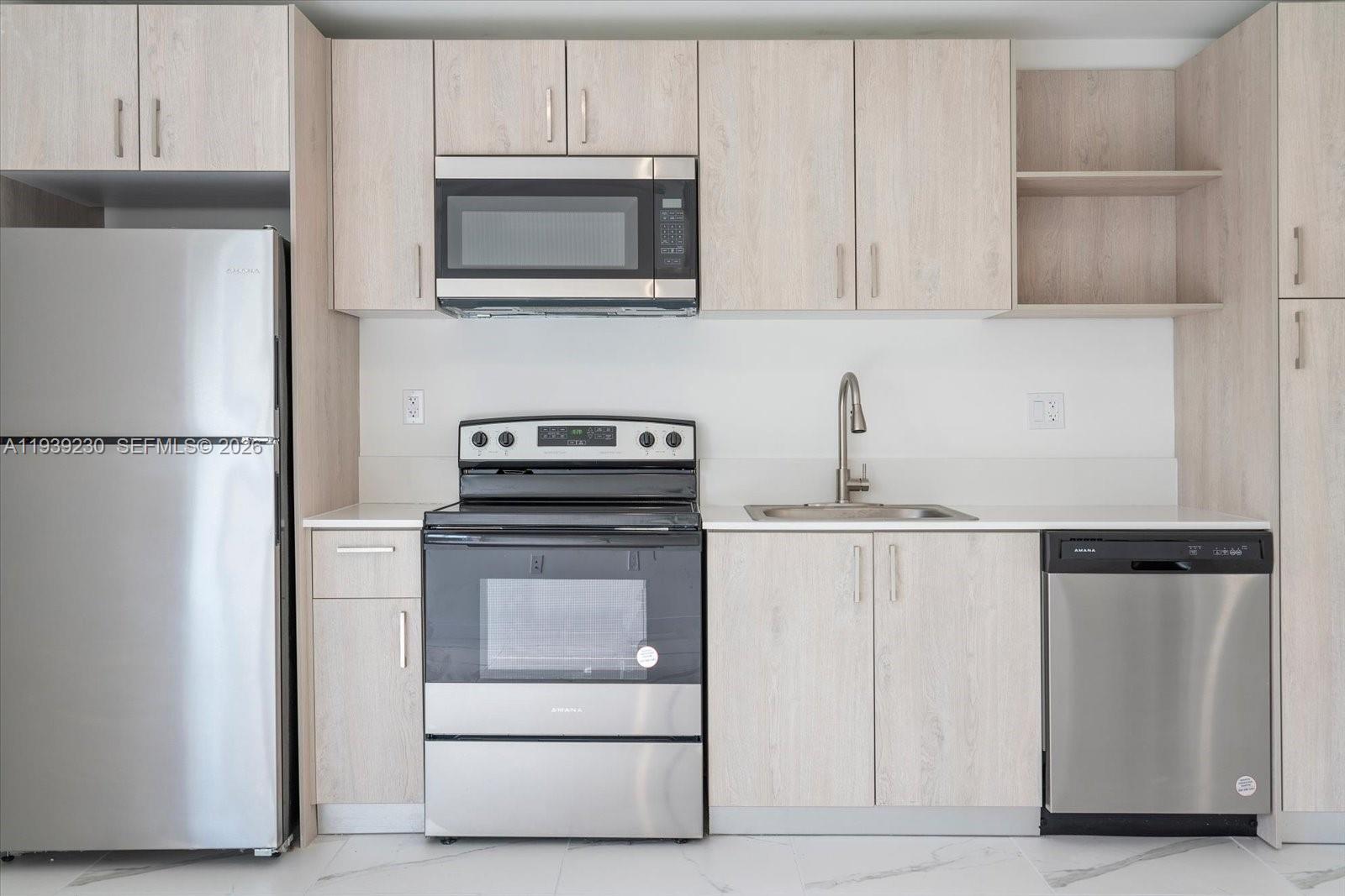 420 Southwest 7th Avenue, Unit 202 Miami, FL 33130 - Photo 1 of 19 a kitchen with appliances a refrigerator and cabinets