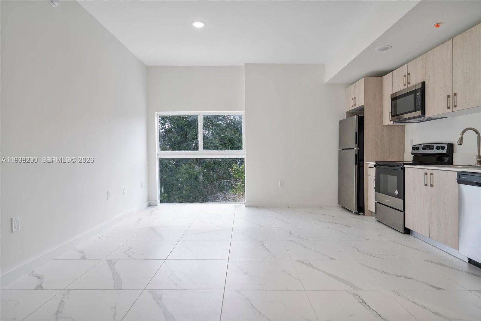 420 Southwest 7th Avenue, Unit 202 Miami, FL 33130 - Photo 2 of 19 a view of kitchen with granite countertop cabinets and refrigerator