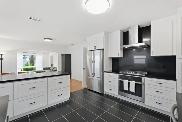 a kitchen with white cabinets stainless steel appliances and sink