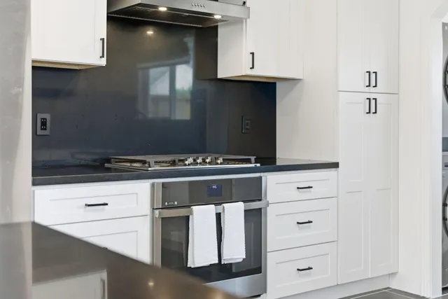 a kitchen with white cabinets and appliances