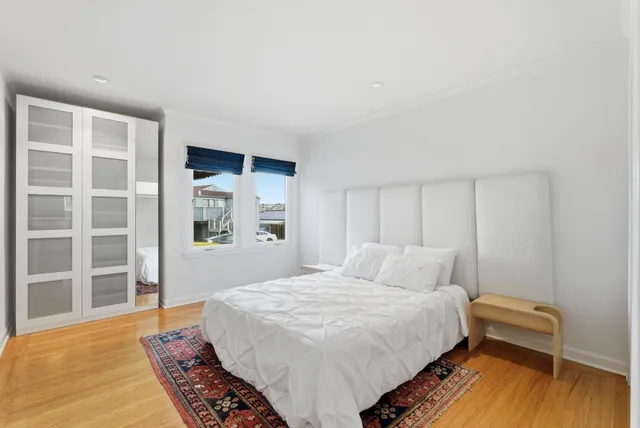 a bedroom with a bed and a large window