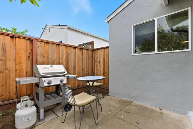 a backyard of a house with table and chairs