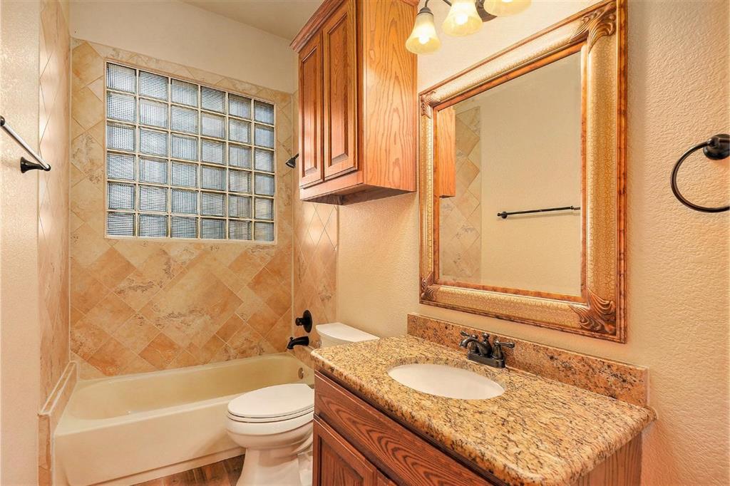 112 Bonita Drive Springtown, TX 76082 - Photo 24 of 39 a bathroom with a granite countertop sink toilet and shower