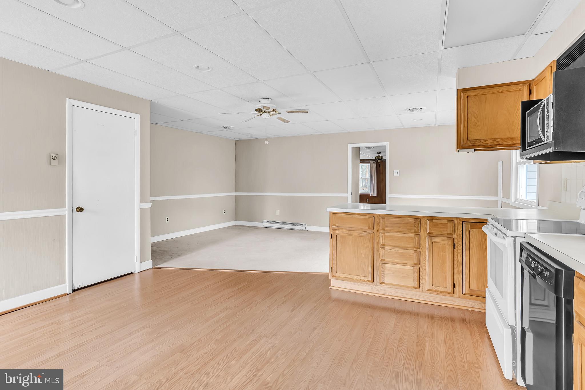 26919 Fitzgerald Road Princess Anne, MD 21853 - Photo 22 of 84 a view of a kitchen with wooden cabinet a fireplace a exposed radiator and wooden floor
