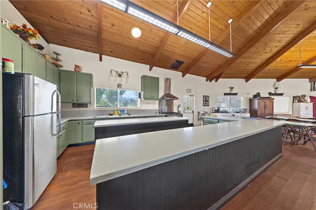 a large white kitchen with wooden floor