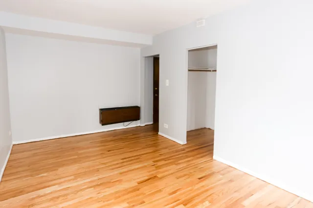 a view of empty room with wooden floor
