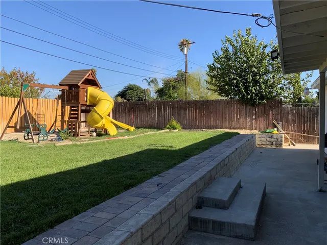 a view of swimming pool with a backyard and a bench