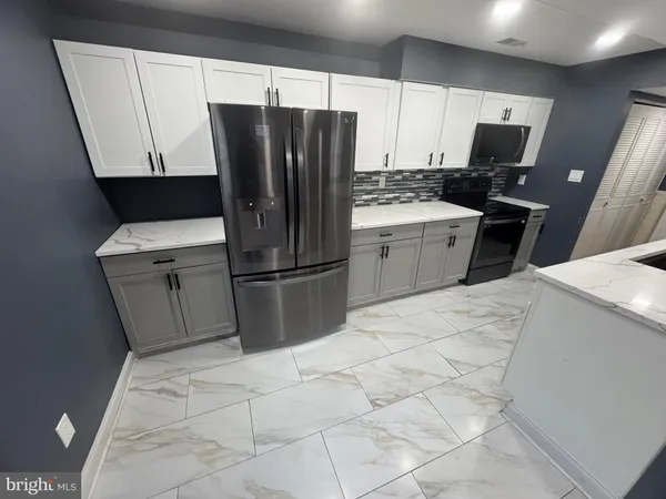 a kitchen with stainless steel appliances a refrigerator sink and microwave