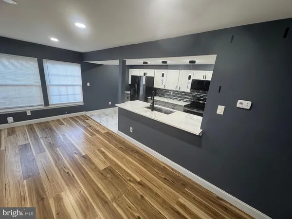 a view of kitchen with sink and refrigerator