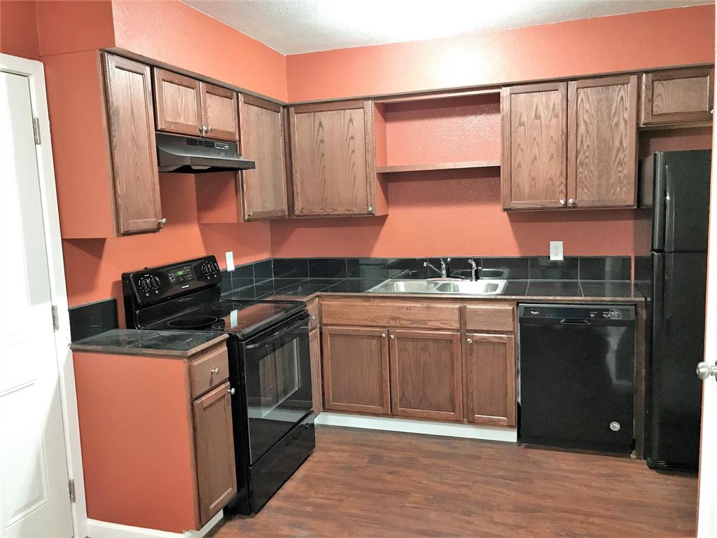 a kitchen with granite countertop a stove top oven cabinetry and granite counter top