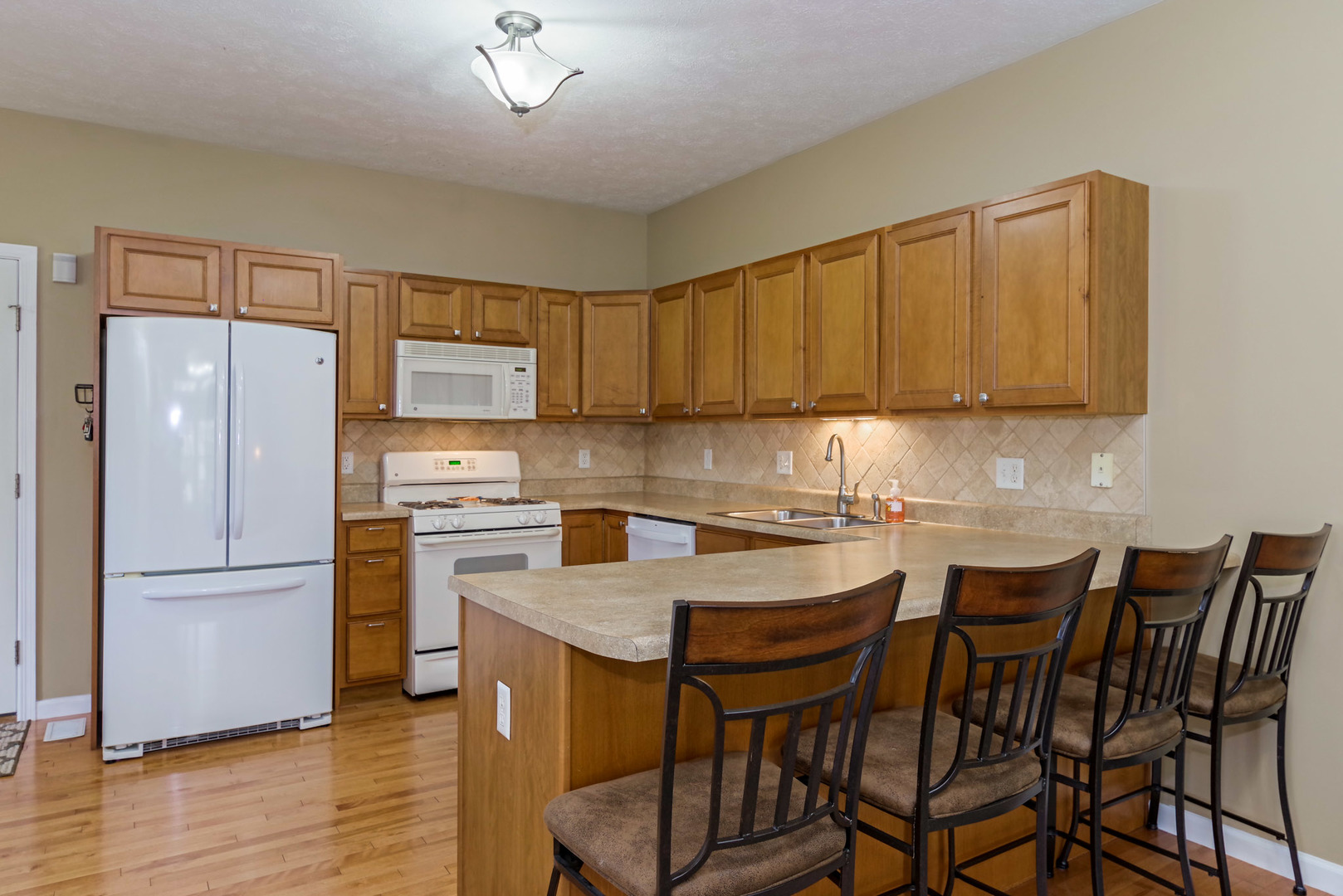 1611 Belclare Road Normal, IL 61761 - Photo 9 of 34 a kitchen with stainless steel appliances granite countertop a dining table chairs refrigerator and sink