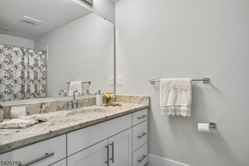 723 Station Road Dunellen, NJ 08812 - Photo 19 of 32 a bathroom with a granite countertop sink and a mirror