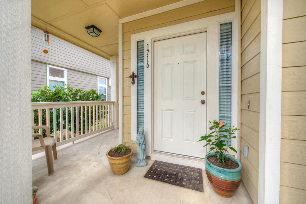 a view of a porch with a chair and potted plant