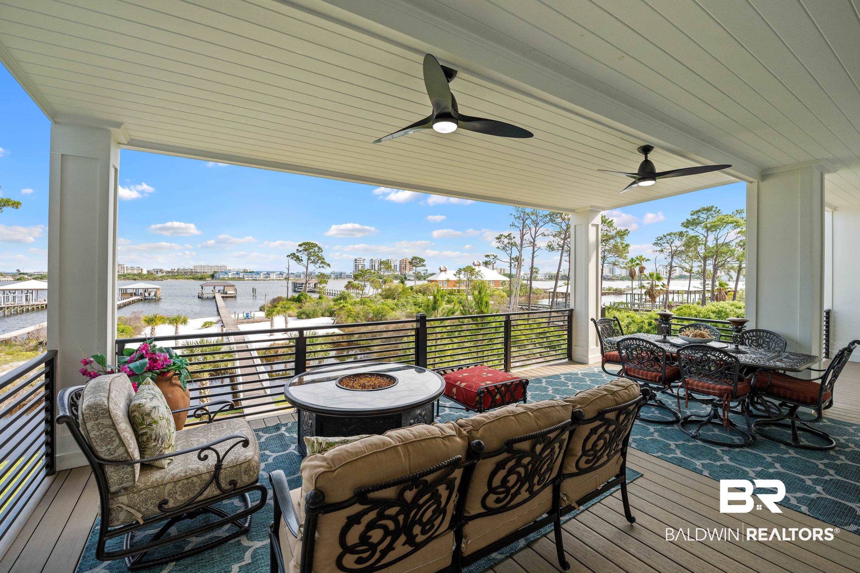 30954 River Road Orange Beach, AL 36561 - Photo 18 of 59 Deck with a water view, an outdoor living space with a fire pit, and ceiling fan
