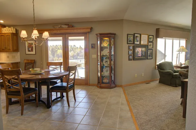 a kitchen with stainless steel appliances kitchen island granite countertop a table chairs sink and cabinets