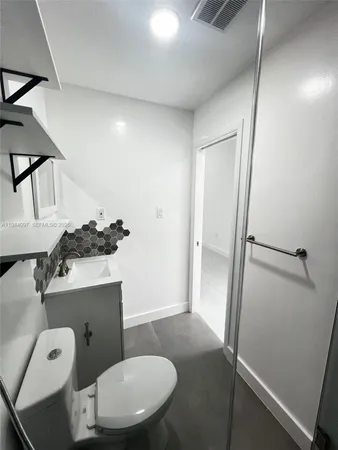 a bathroom with a toilet a sink and mirror