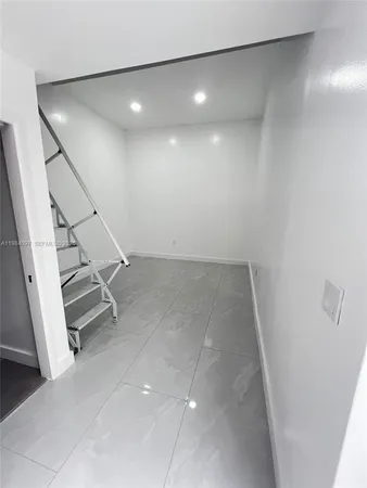 an empty room with white walls and stairs