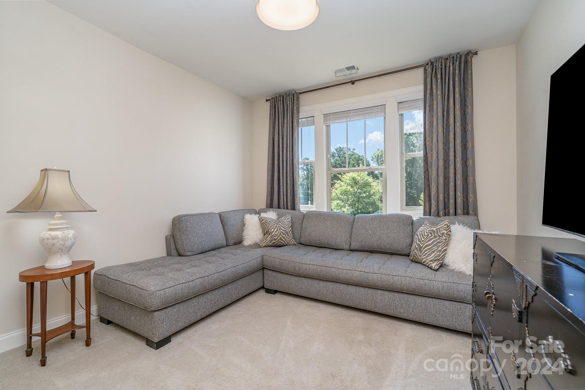 104 Smithfield Drive Charlotte, NC 28270 - Photo 20 of 39 a living room with furniture and a flat screen tv