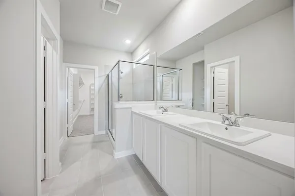a bathroom with a double vanity sink mirror and shower